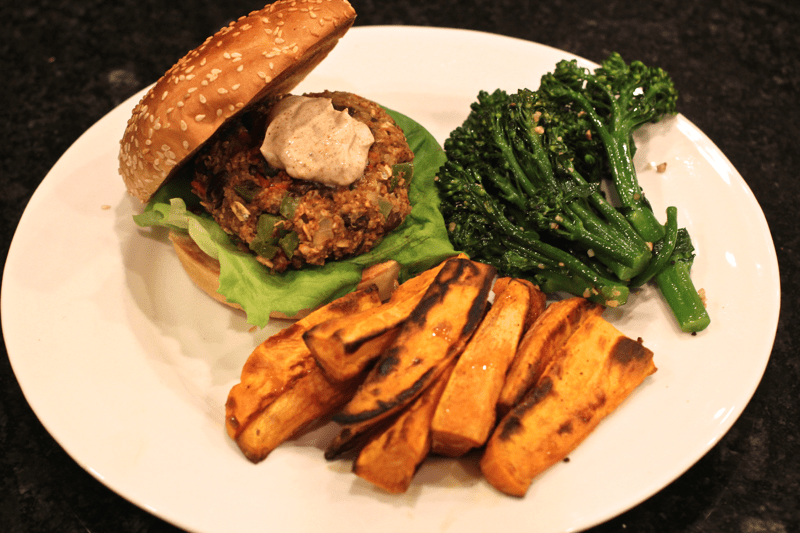 Fiesta black bean burger dinner with sweet potato fries and broccolini.