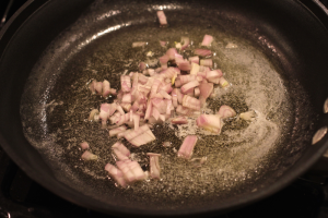 Shallot being sautéed in a skillet