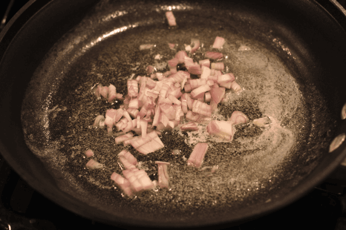 Sautéed finely chopped shallots in a skillet.