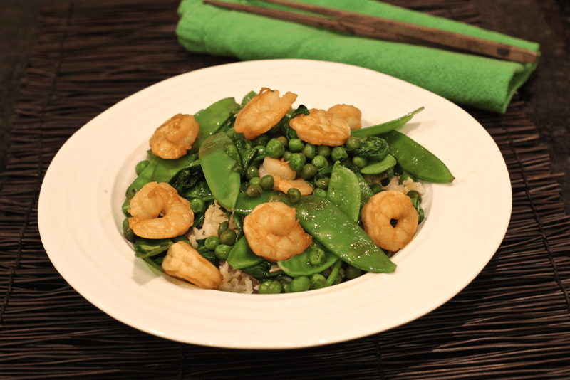 Shrimp and snow pea stir fry served in a white bowl.