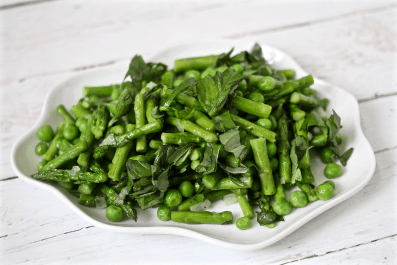 Asparagus and peas with basil served on a white plate