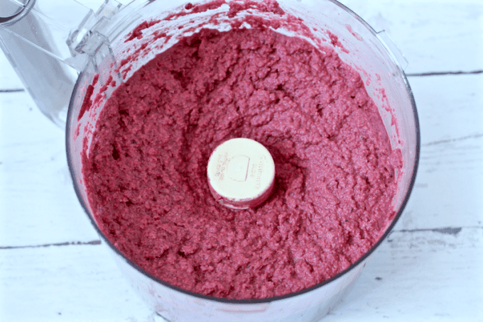 Pureed beet hummus in a food processor.