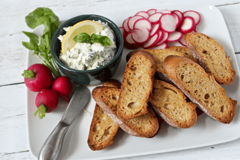 Cheese and herb spread served on a platter for an appetizer