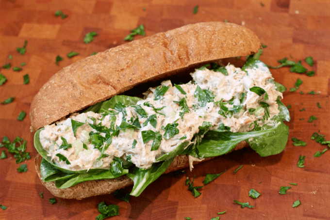 Crab roll sandwich with spinach on a whole grain loaf roll