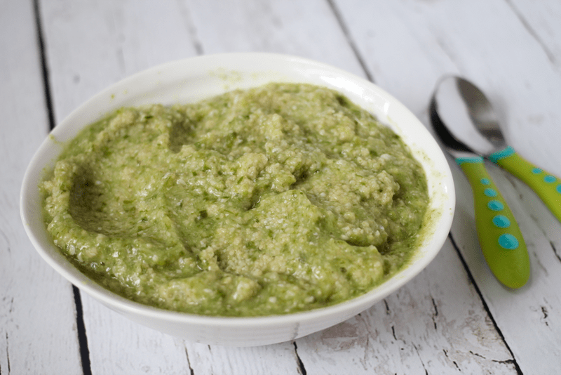 A green mixture of pureed okra mixed with couscous in a white bowl.