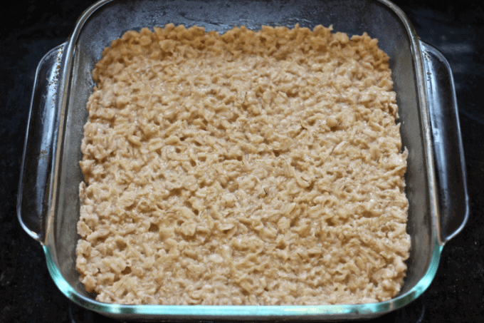 A square glass baking dish with oatmeal pressed into it.