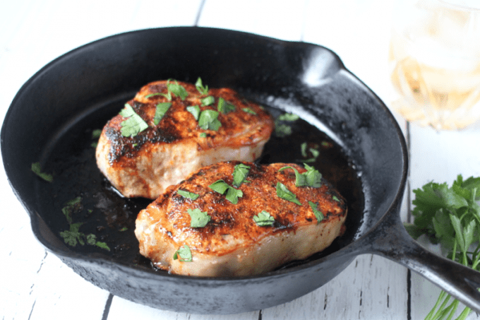 Spice-rubbed pork chops seared in a cast iron skillet