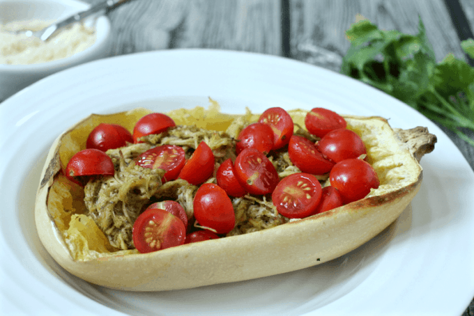 Spaghetti squash with pesto chicken and halved cherry tomatoes on top