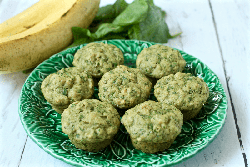 A small green leafy plate with mini spinach muffins.