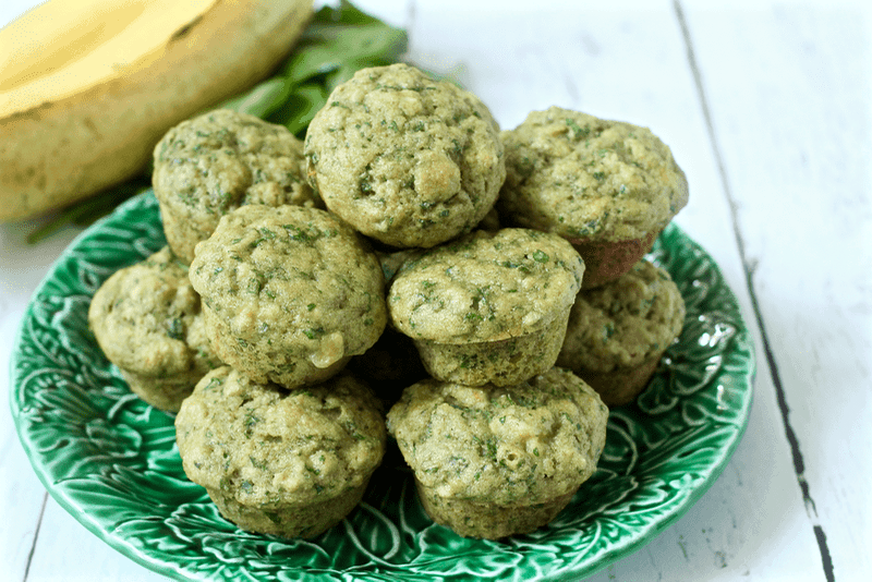 Spinach banana mini muffins stacked on a green plate/