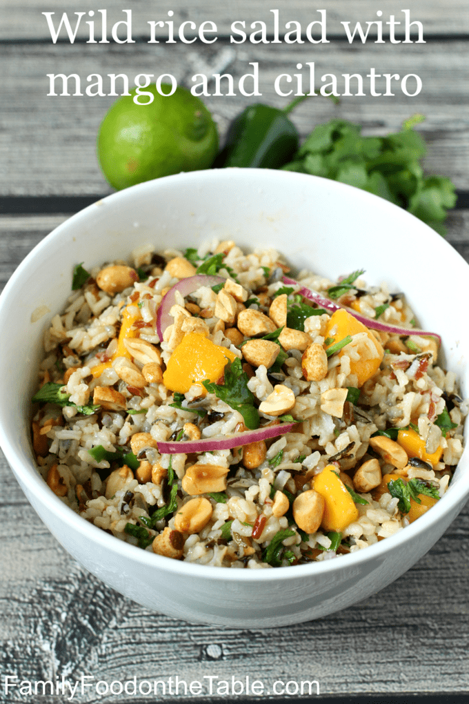 Close up of a white serving bowl with a wild rice salad with mango, peanuts and cilantro.