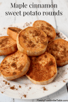 A pile of roasted sweet potato rounds on a white plate with cinnamon sprinkled all over top.