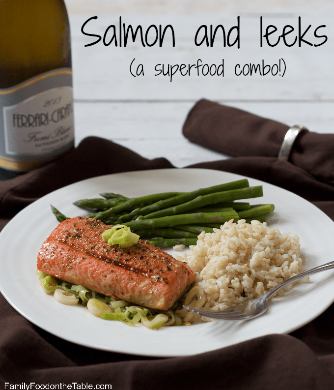 A plate of salmon with leeks alongside steamed rice and asparagus