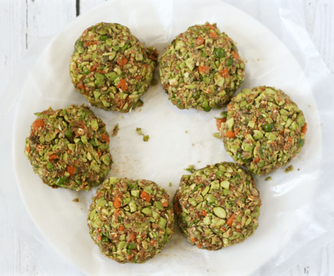 Veggie burger patties on a white plate with wax paper