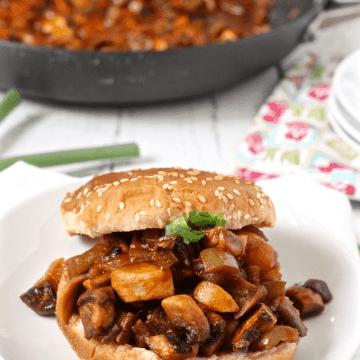 A mushroom and vegetable version of sloppy Joe's served on a bun with the skillet in the background.