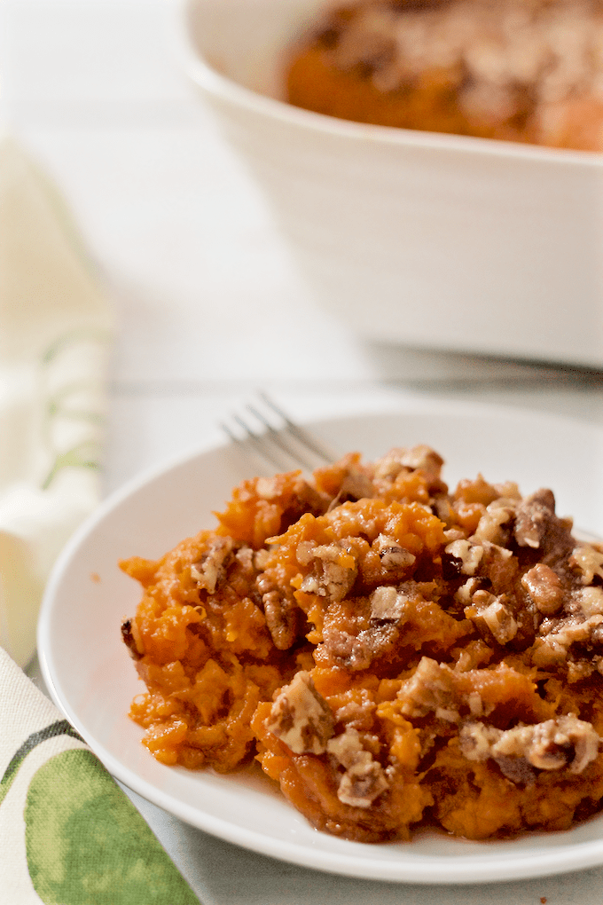 Bourbon sweet potato casserole with pecans served on a white plate