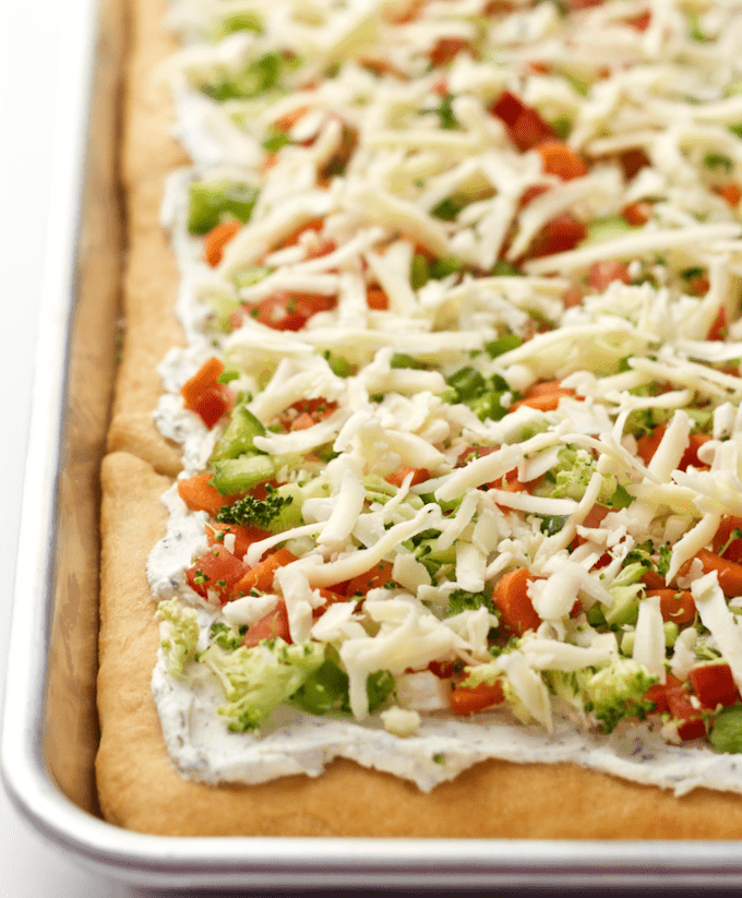 Easy vegetable squares are crescent rolls spread with a cream cheese mixture, sprinkled with veggies and cheddar and served cold for a great veggie pizza appetizer! #appetizer #gameday #holidays #pizza #easyrecipe