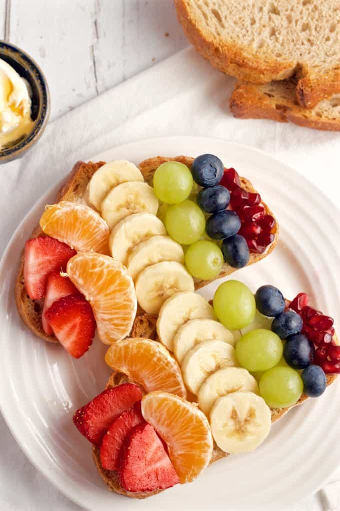 Rainbow fruit - A fun fruit toast with cream cheese, honey and all the colors of the rainbow! | FamilyFoodontheTable.com