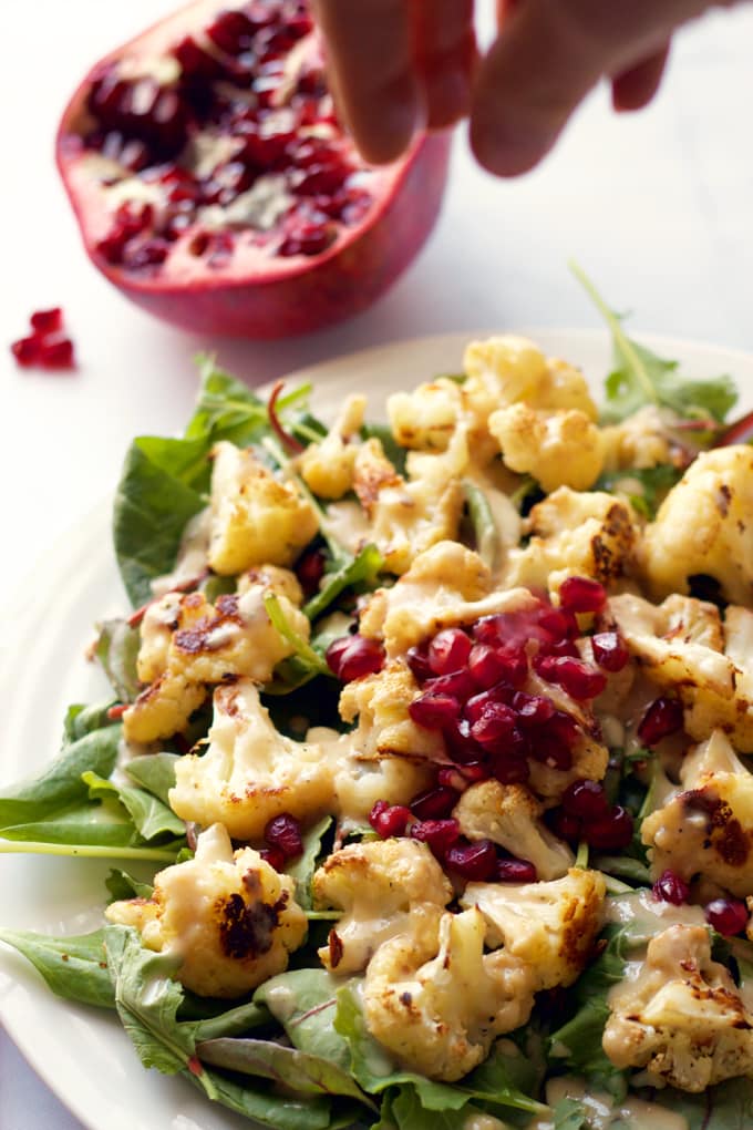 Baby kale and roasted cauliflower salad sprinkled with pomegranate seeds | FamilyFoodontheTable.com
