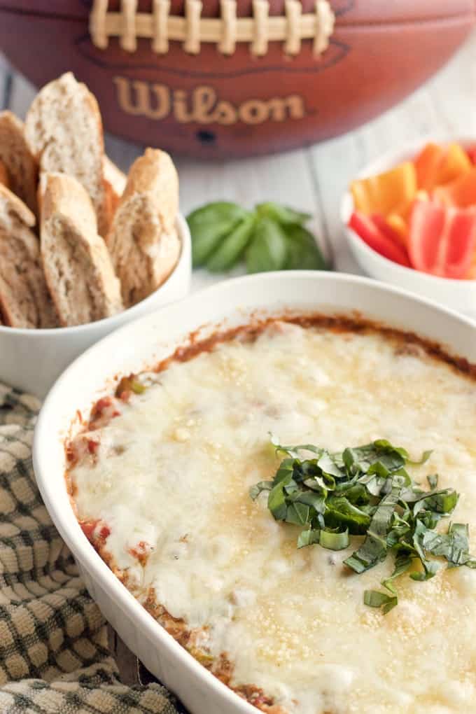 Cheesy veggie-packed pizza dip - great game day or party appetizer-- Sure to be a hit with everyone! | FamilyFoodontheTable.com