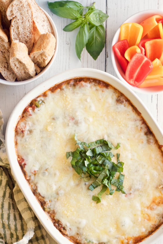 Cheesy veggie-packed pizza dip - great party appetizer everyone will love! | FamilyFoodontheTable.com