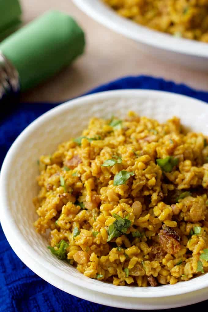 This easy one-pot cold curried rice salad with bright citrus notes and raisins, nuts and cilantro folded in makes for a flavorful side dish. Fluffy brown rice salad served in a white bowl