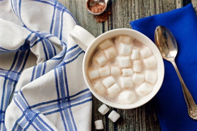 A white coffee mug with hot cocoa and mini marshmallows