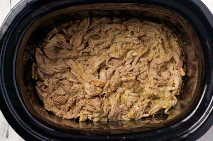 Cooked shredded pork in the slow cooker with salsa verde