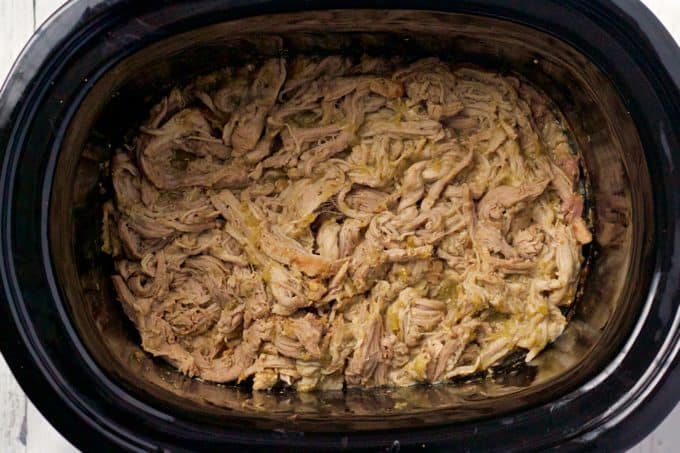 Cooked shredded pork in the slow cooker with salsa verde