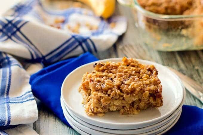 Baked oatmeal served on a white plate with blue napkins nearby