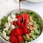 Arugula salad with strawberries, pistachios and goat cheese