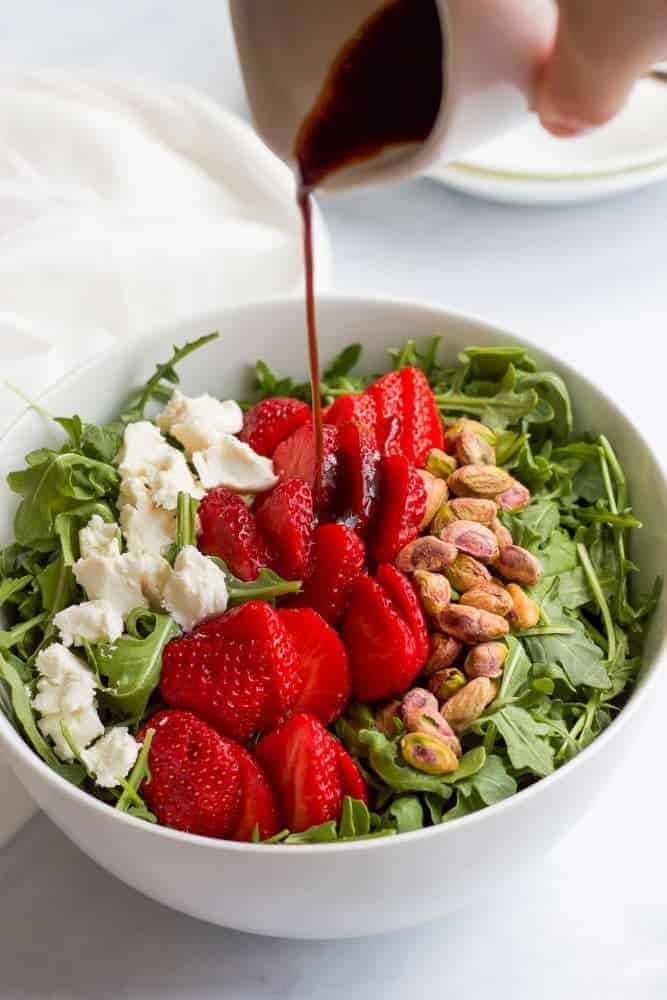 This baby arugula salad with strawberries, pistachios, goat cheese and an easy homemade balsamic vinaigrette is perfect for a fresh and healthy spring or summer salad! #arugula #saladrecipes #healthysalads