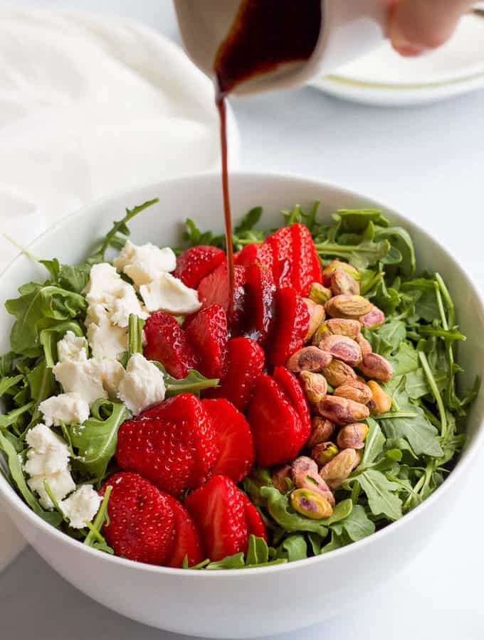 Baby arugula salad with strawberries, pistachios, goat cheese and an easy homemade balsamic vinaigrette! | FamilyFoodontheTable.com