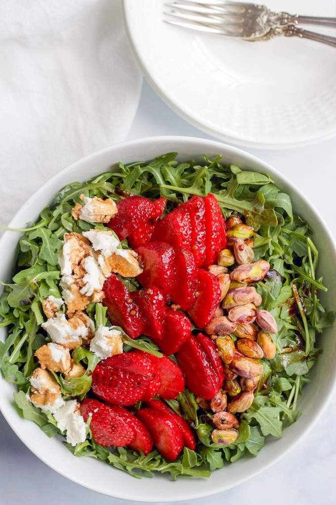 Baby arugula, strawberries, pistachios and goat cheese, all drizzled with an easy homemade balsamic vinaigrette! | FamilyFoodontheTable.com