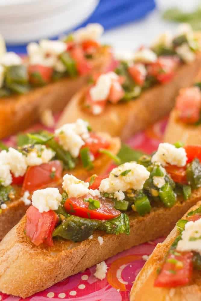 Close up of toasted bruschetta with poblanos, tomatoes, jalapenos and toppings