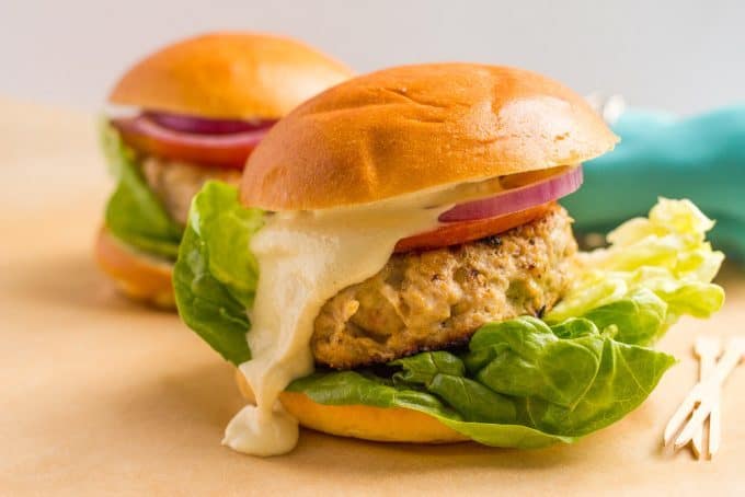 Cheddar chicken burgers served with toppings and a creamy sauce