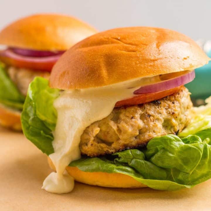 Cheddar chicken burgers served with toppings and a creamy sauce