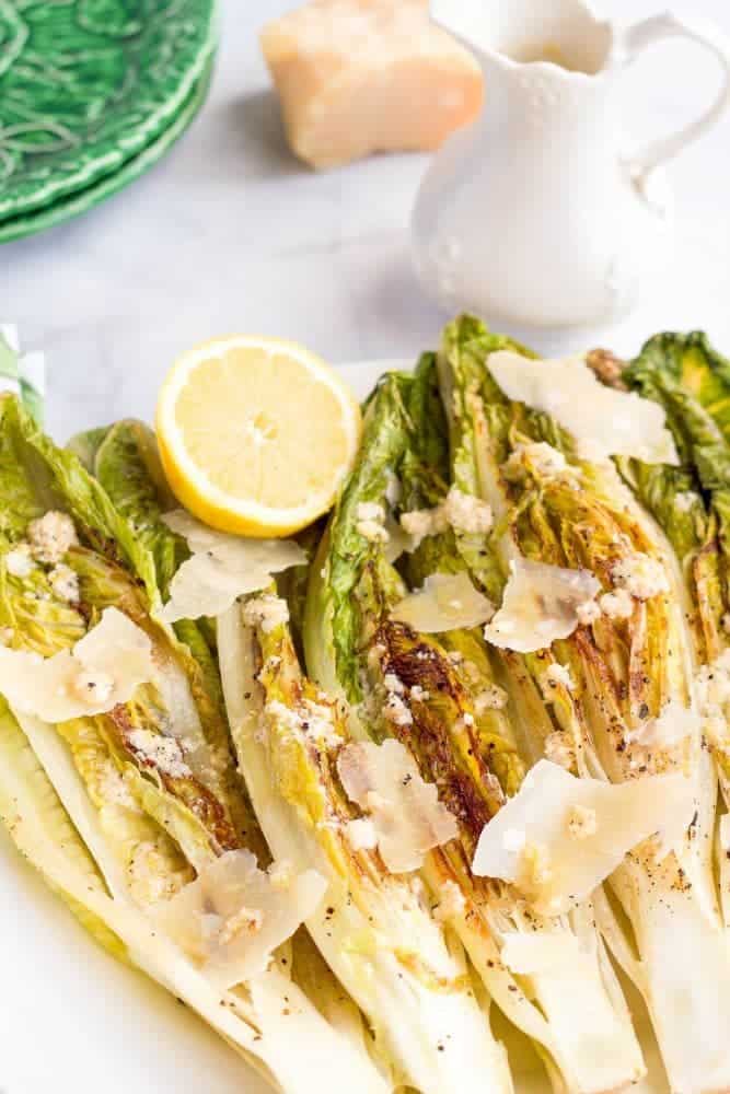 Seared romaine with Parmesan cheese displayed on a white platter