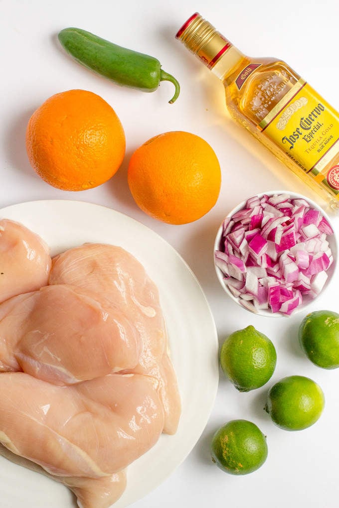 Ingredients laid out in separate plates and bowls for making a tequila chicken recipe.