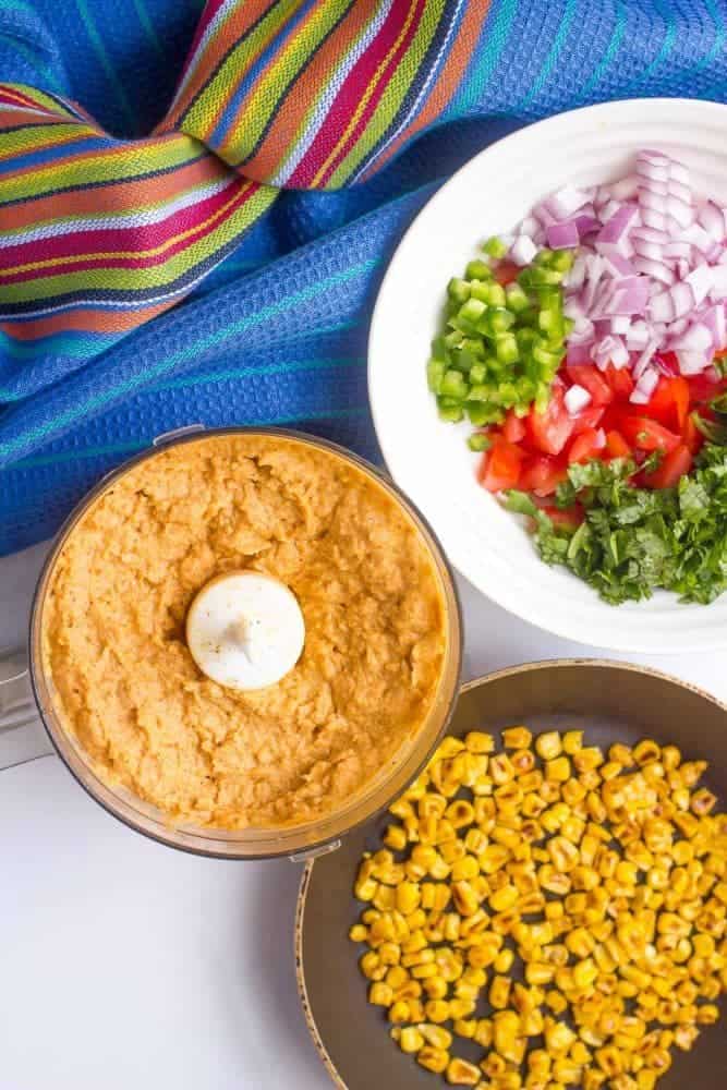 Southwestern hummus ingredients and toppings laid out in bowls