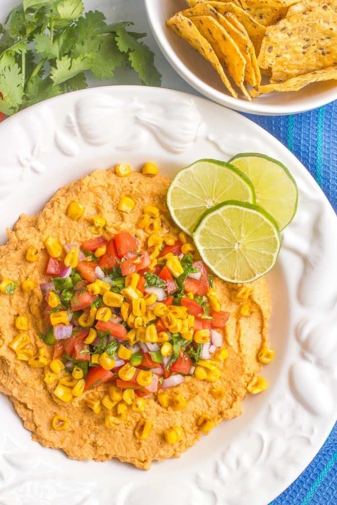 Southwestern hummus dip is topped with an easy, fresh pico de gallo and charred corn for a fun and tasty appetizer! #hummus #salsa #appetizer #gamedayeats #healthysnacks