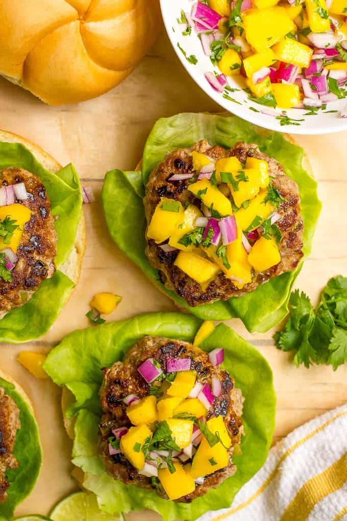 These easy spicy pork burgers have a hint of heat and a cool, refreshing mango salsa to pile up on top. These flavorful burgers are great summer fare for dinner or cookouts!