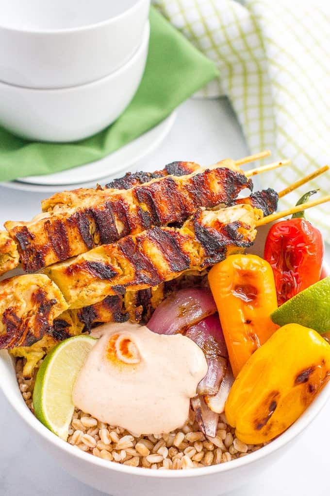 Chili lime chicken kabobs in a bowl with farro, peppers and a creamy, smoky adobo sauce - a tasty, healthy summer dinner!