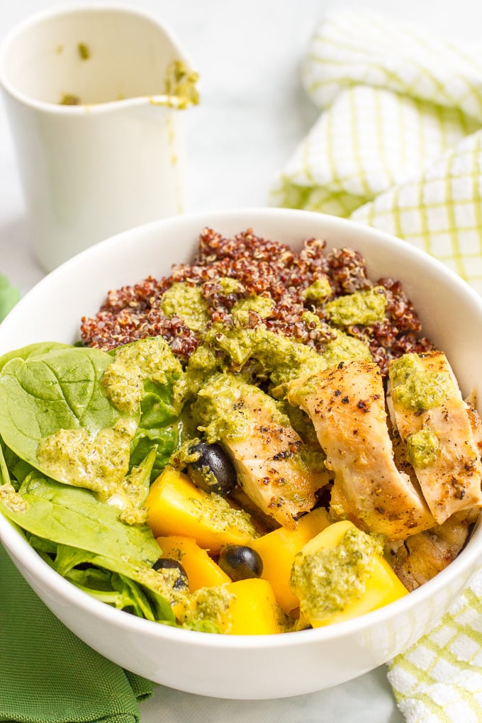Chicken quinoa salad bowls are a quick and healthy dinner featuring chicken thighs, red quinoa, fresh fruit and a zesty lemon-mint dressing!