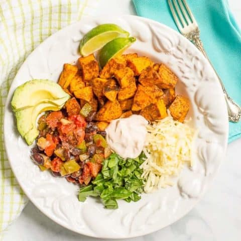 A taco-flavored vegetarian power bowl with sweet potatoes, black beans and a spiced yogurt sauce - an easy, healthy vegetarian dinner!