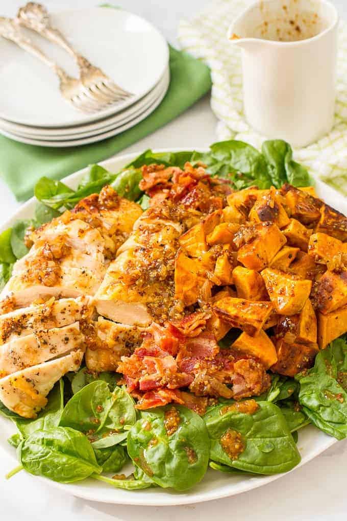 Warm chicken and sweet potato salad with bacon vinaigrette, served over fresh spinach, is a hearty main dish salad with big bacon flavor! | www.familyfoodonthetable.com