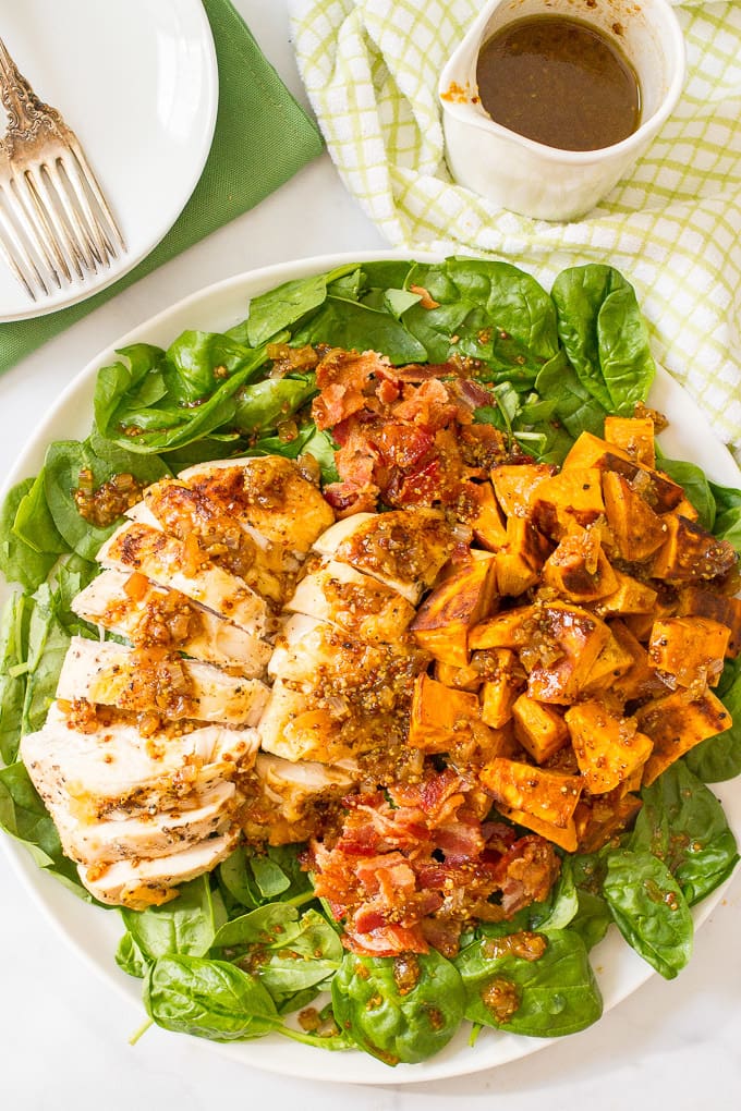 Warm chicken and sweet potato salad with bacon vinaigrette, served over fresh spinach, is a hearty main dish salad with big bacon flavor! | www.familyfoodonthetable.com