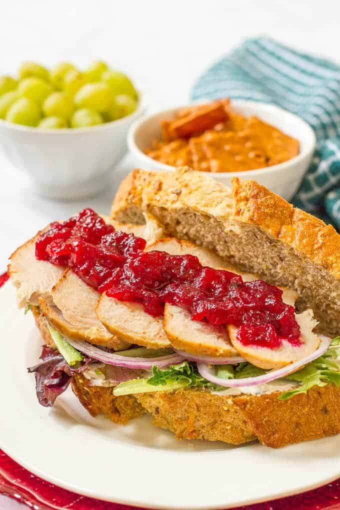 Leftover Thanksgiving turkey sandwiches with cream cheese, cranberry sauce, greens and red onion - a delicious easy lunch! | www.familyfoodonthetable.com