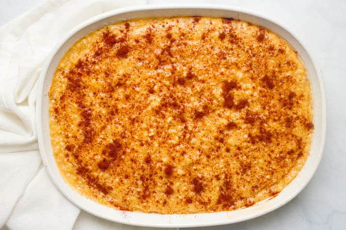 Make ahead cheesy grits casserole with paprika sprinkled on top