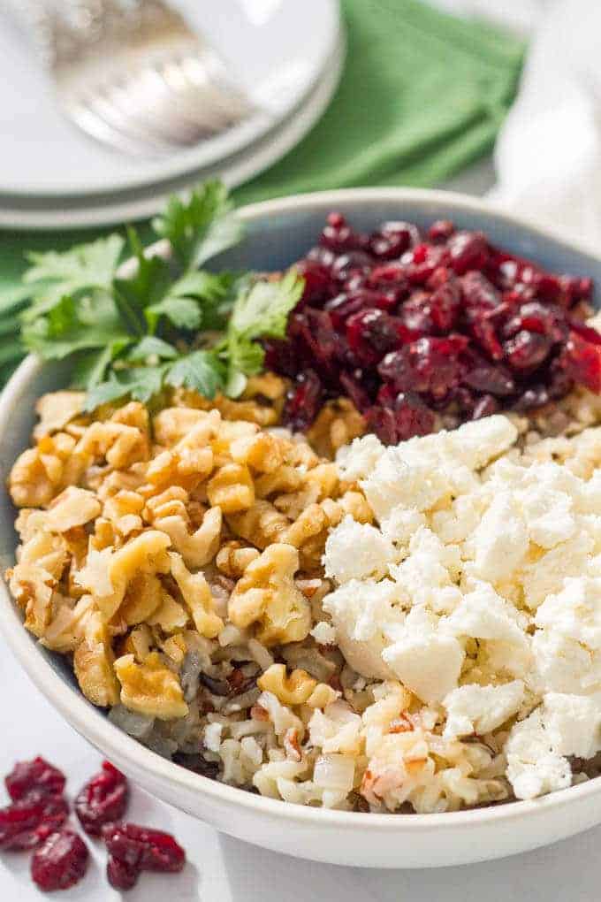 Warm wild rice salad with cranberries, pecans and goat cheese is a delicious combination of flavors and textures - perfect for a winter side dish! #wildrice #ricesalad #holidayfood #sidedish